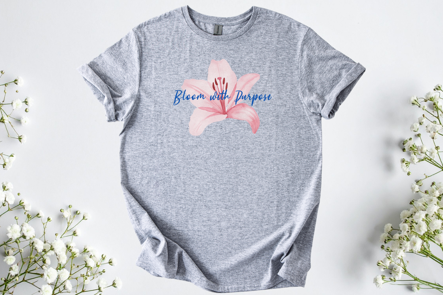 Gildan Softstyle Unisex Shirt in heather gray with pink flower and "Bloom with Purpose" text, soft and breathable motivational tee.