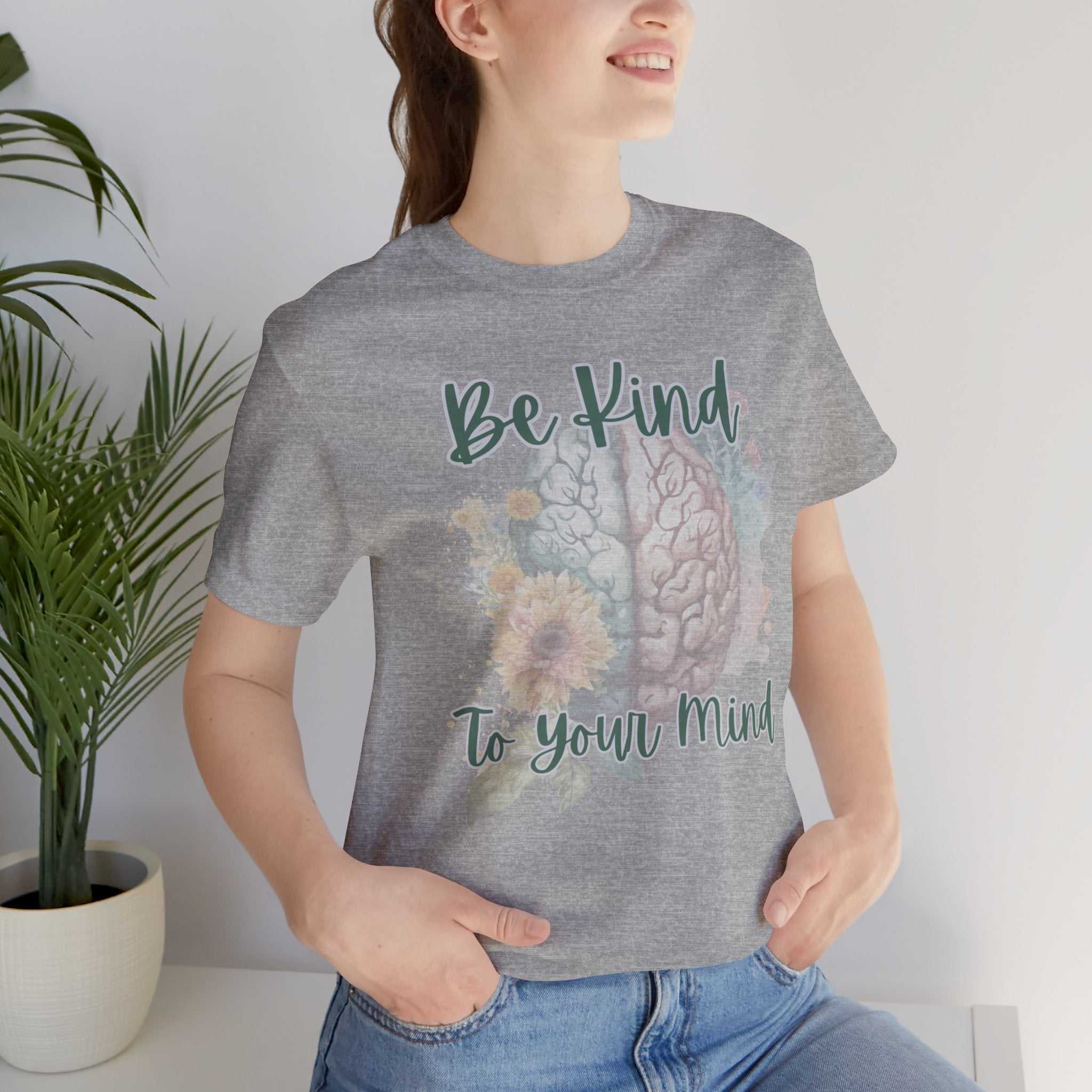 Woman wearing "Be Kind To Your Mind" mental health affirmation t-shirt with floral brain design.