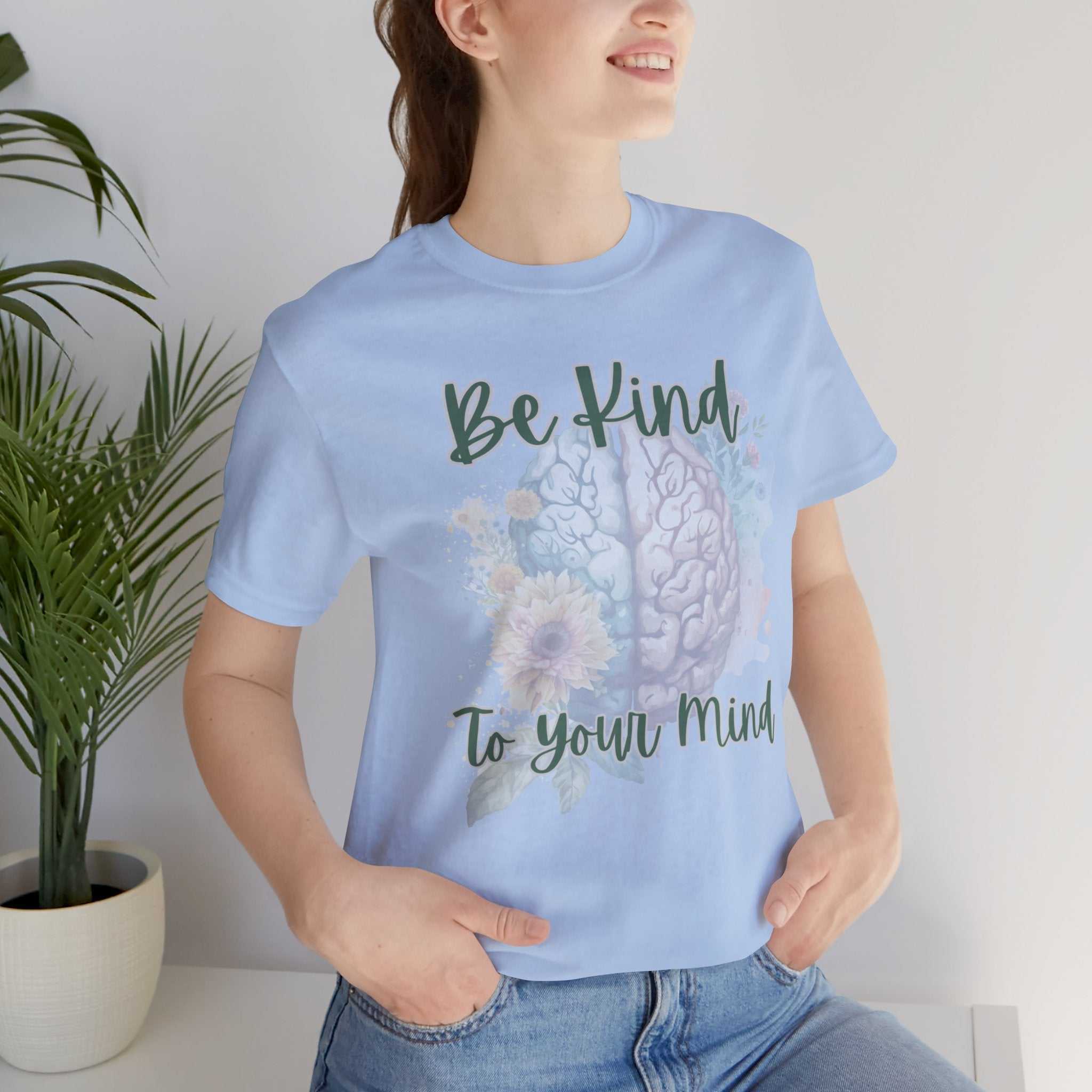 Woman wearing "Be Kind To Your Mind" mental health affirmation t-shirt with floral brain design.