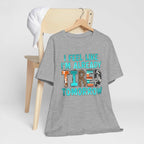 T-Shirt with "I Feel Like I'm Already Tired Tomorrow" phrase, promoting mental health awareness, in bold, colorful letters on soft gray fabric.