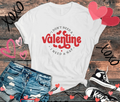 Anti-Valentine T-shirt with "I Don't Need A Valentine, I Need A Nap" text, styled with casual denim shorts and sneakers, surrounded by heart and "XOXO" doodles.