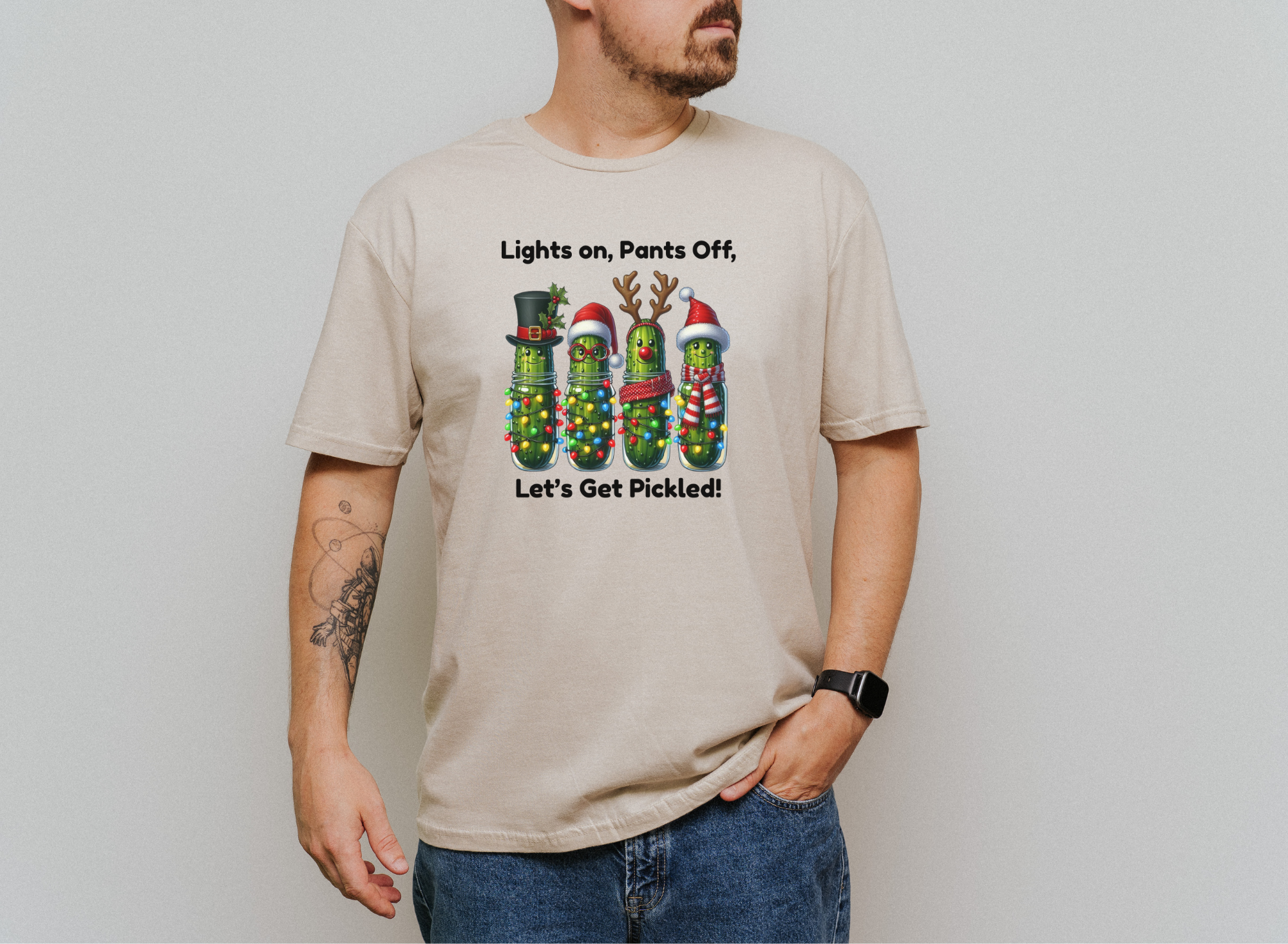 Men's beige Let's Get Pickled holiday t-shirt with festive pickles decorated in Christmas lights and hats