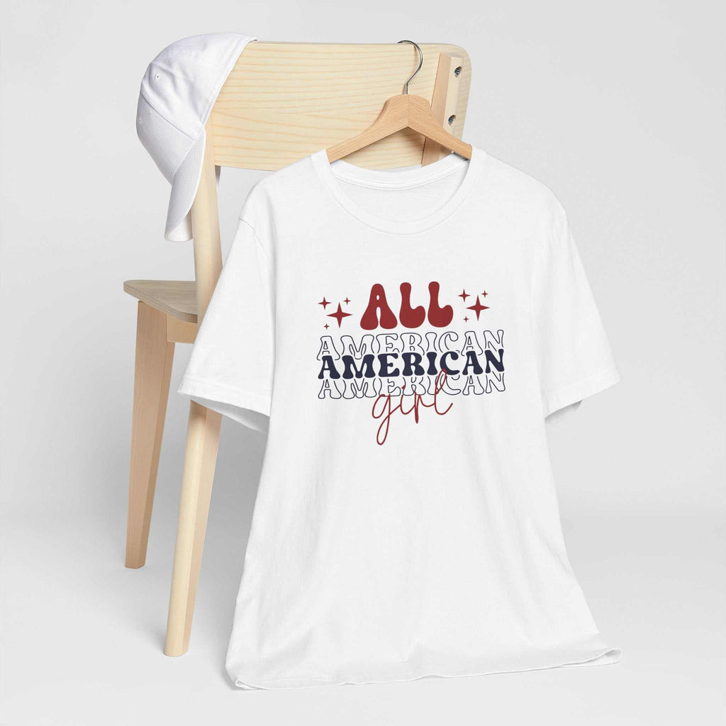 American Girl Independence Day T-Shirt with red, white, and blue graphics on a hanger.