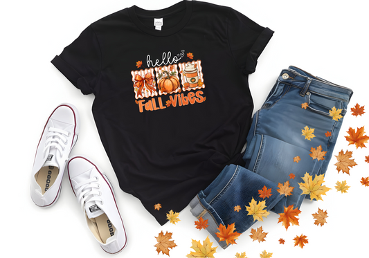 Black Hello Fall Vibes softstyle shirt with pumpkins and coffee design, paired with jeans and white sneakers surrounded by autumn leaves