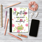 Motivational journal with pink floral cover and personalized name on wooden desk with pens, phone, earphones, and scrunchie.
