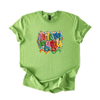 White tee with "Autism Mama" rainbow yarn-style lettering and floral accents