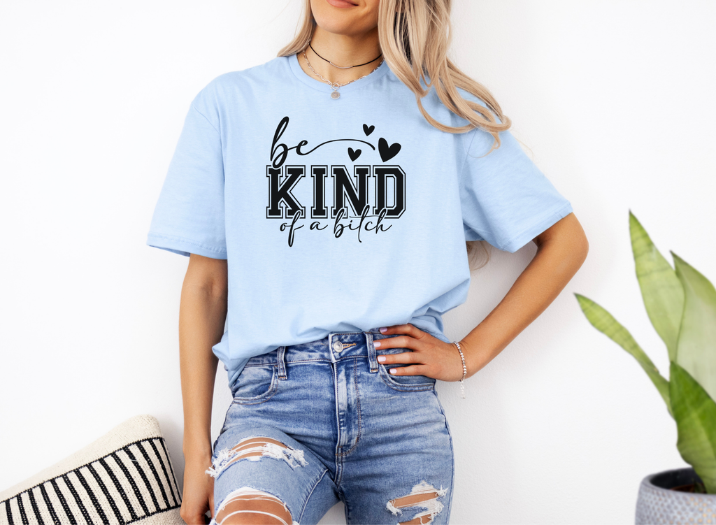 Woman wearing light blue "Be Kind of a Bitch" softstyle t-shirt paired with ripped jeans, casual stylish look