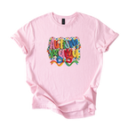 White tee with bold Autism Mama Rainbow crochet-style yarn lettering and colorful floral accents