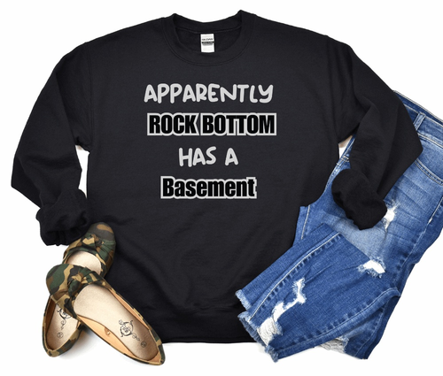Unisex black sweatshirt with "Apparently Rock Bottom Has A Basement" quote, humor gift for men and women.