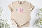 Gildan Softstyle Unisex Shirt in beige with pink flower and "Bloom with Purpose" text, soft and breathable motivational tee
