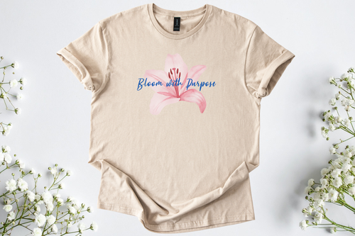 Gildan Softstyle Unisex Shirt in beige with pink flower and "Bloom with Purpose" text, soft and breathable motivational tee