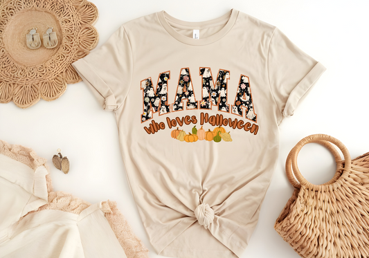 Beige softstyle shirt with "MAMA who loves Halloween" text and autumn-themed graphics, styled with fall accessories