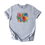 White tee with bold Autism Mama Rainbow yarn-style graphic and colorful floral accents