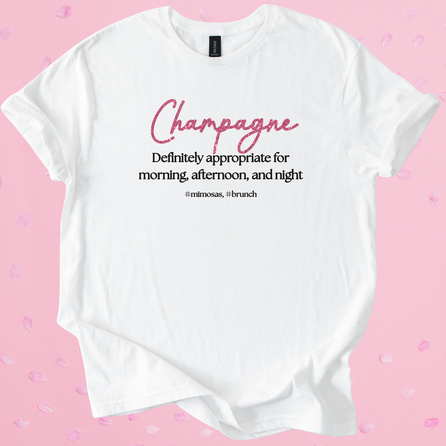 White Gildan Softstyle T-shirt with pink text "Champagne" and black slogan "Definitely appropriate for morning, afternoon, and night" promoting Champagne Brunch style